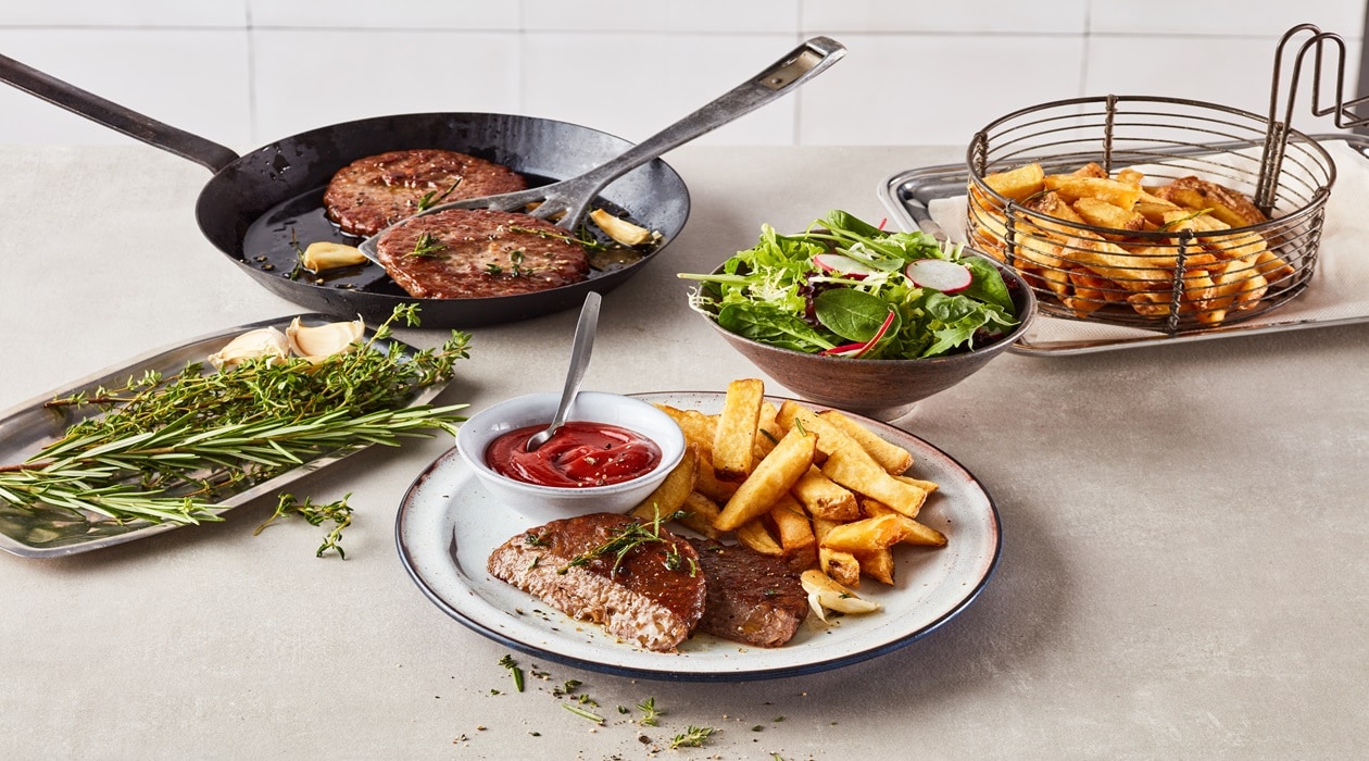 Hambúrguer vegan no prato com salada verde